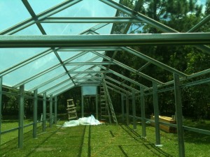 Metal greenhouse roofing being installed